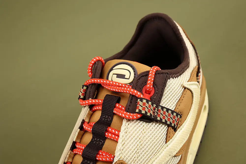 Air Max 1 Cactus Jack Wheat Lemon Drop DO9392-701 - Full Lateral Profile View on Olive Background Showing Wheat Leather AM1 Upper Lemon Drop Waffle Mesh Quarter Panel Reversed Lemon Drop Suede Swoosh Diamond-Pattern Woven Ribbon Heel Pull Tab and Red Pennant Flag Badge