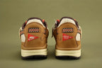 Air Max 1 Cactus Jack Wheat Lemon Drop DO9392-701 - Full Outsole View on Olive Background Showing Dark Brown Baroque Brown Rubber Outsole Square-Block and Circular Traction Pattern and White CACTUS CORPORATION Text at Outsole Heel