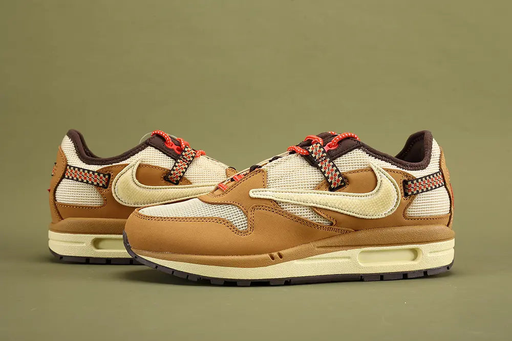 Air Max 1 Cactus Jack Wheat Lemon Drop DO9392-701 - Full Medial Profile View on Olive Background Showing Wheat Leather AM1 Upper Lemon Drop Waffle Mesh Quarter Panel Diamond-Pattern Woven Ribbon Badge on Medial Heel and Lemon Drop Aged Midsole