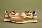 Air Max 1 Cactus Jack Wheat Lemon Drop DO9392-701 - Full Medial Profile View on Olive Background Showing Wheat Leather AM1 Upper Lemon Drop Waffle Mesh Quarter Panel Diamond-Pattern Woven Ribbon Badge on Medial Heel and Lemon Drop Aged Midsole