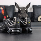 Air Max Plus SE Black Chrome Silver 2024 - Heel Pair Rear View with Yellow Tn Air Badge and Pikachu on Sofa