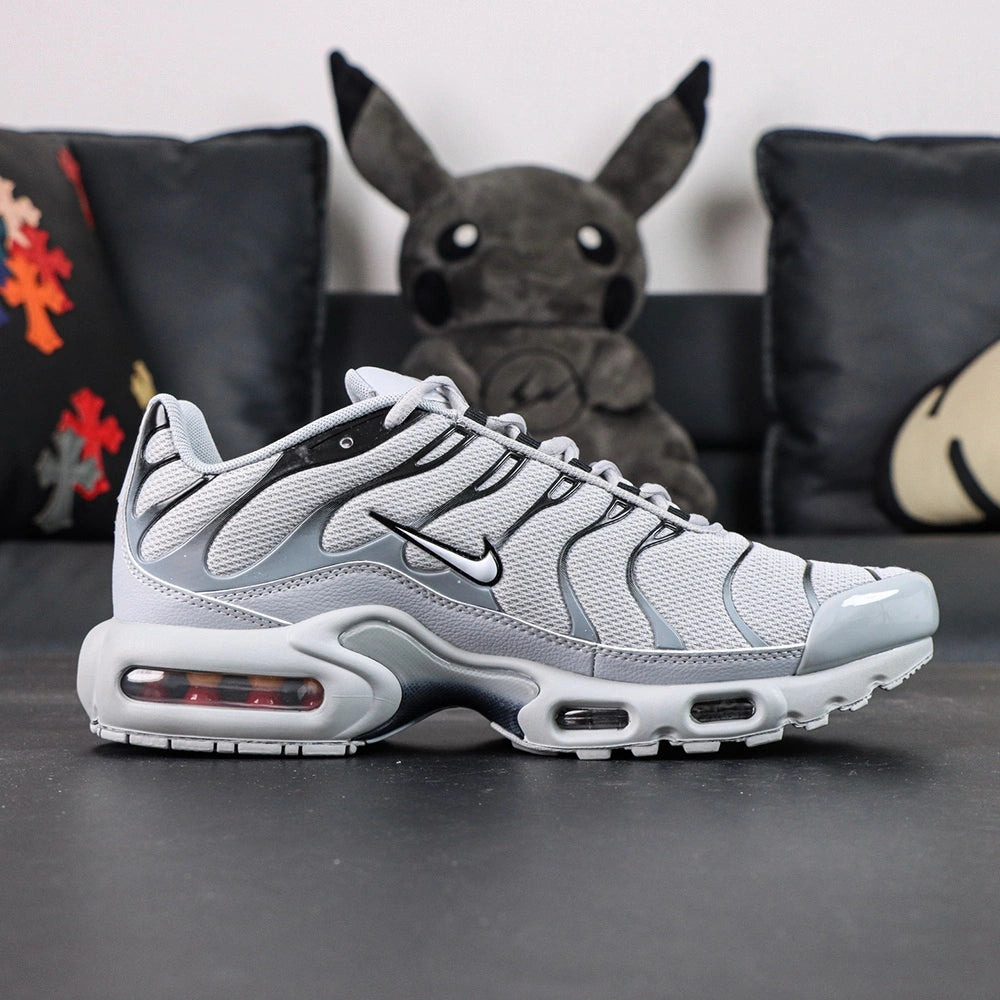 Air Max Plus TN Wolf Grey 2018 - Pair with Outsole Displayed Showing Grey Black Tread and Red Accent Dots with Pikachu on Sofa