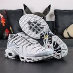 Air Max Plus TN Wolf Grey 2018 - Pair Top Down View on Dark Background Showing Full Black Outline Graphic Upper