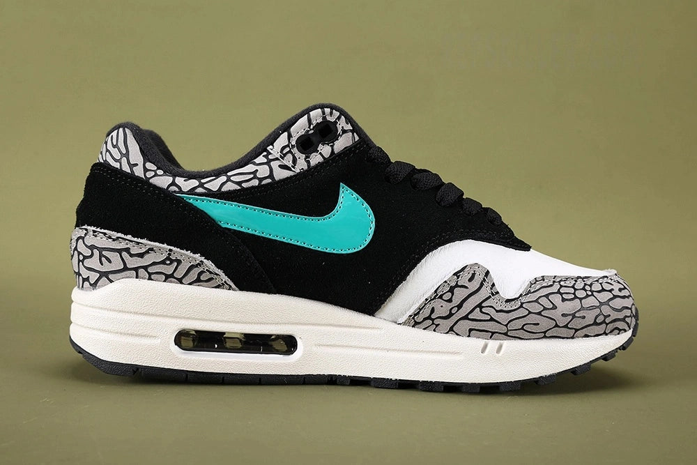 Atmos x Air Max 1 Premium Retro Elephant 2017 - Tongue Close Up Detail Showing Teal Nike Air Max Embroidery and Grey Elephant Print Collar on Sage Background