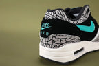 Atmos x Air Max 1 Premium Retro Elephant 2017 - Pair Three Quarter Lateral View Showing Full Elephant Print Upper and Emerald Green Swoosh on Sage Background