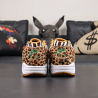 Atmos x Air Max 1 DLX Animal Pack 2018 - Lateral Side View with Pikachu on Sofa Showing Leopard Print Toe Box Zebra Quarter Panel and Red Swoosh