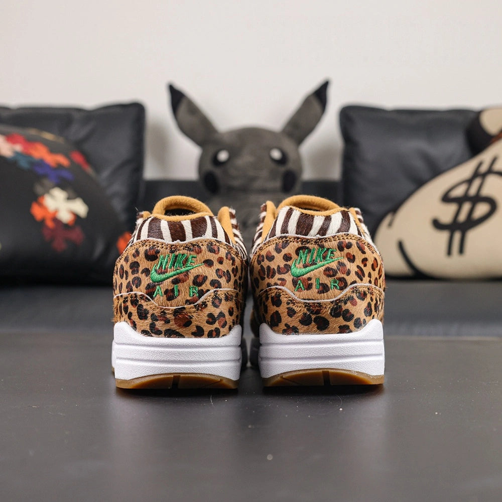 Atmos x Air Max 1 DLX Animal Pack 2018 - Lateral Side View with Pikachu on Sofa Showing Leopard Print Toe Box Zebra Quarter Panel and Red Swoosh