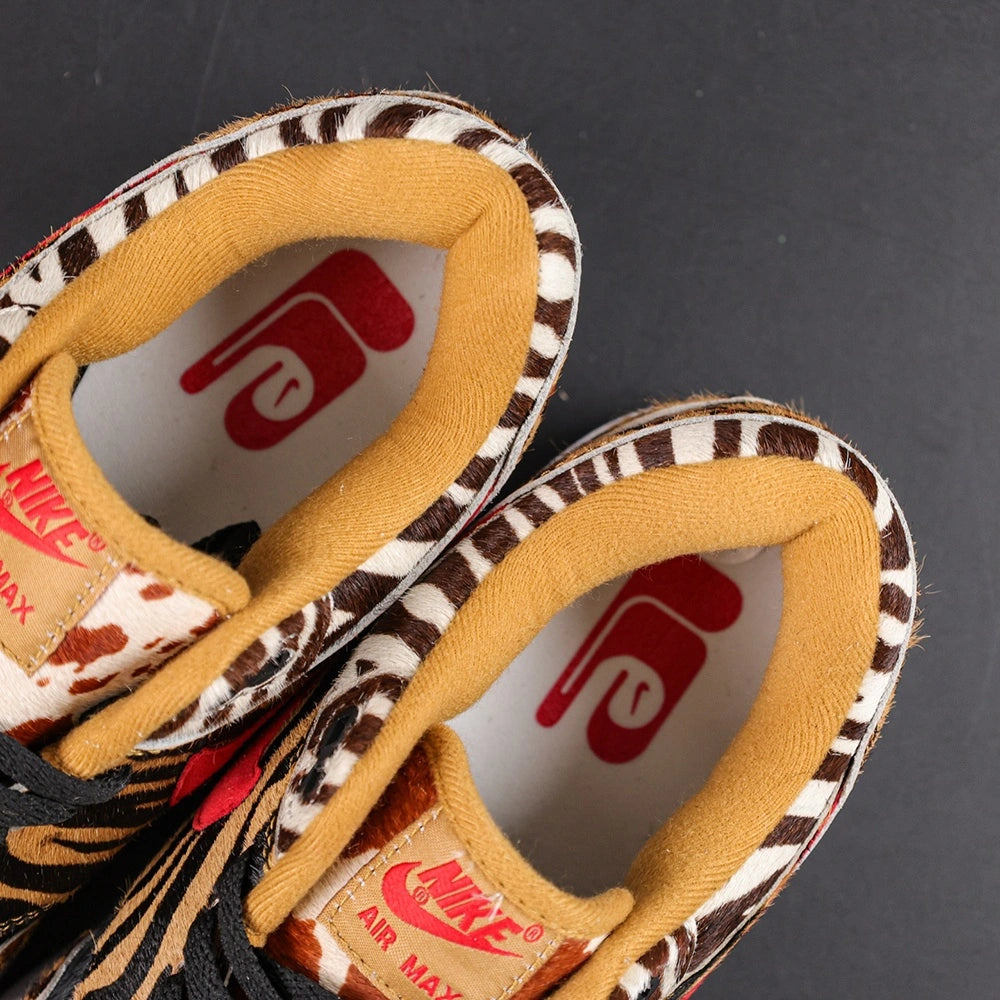 Atmos x Air Max 1 DLX Animal Pack 2018 - Three Quarter Lateral View with Pikachu on Sofa Showing Full Animal Print Upper and Red Swoosh