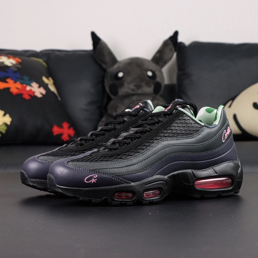 Corteiz x Air Max 95 SP Rules the World Pink Beam - Lateral Side View with Pikachu on Sofa Showing Hot Pink Swoosh and Corteiz Script on Black Leather Upper