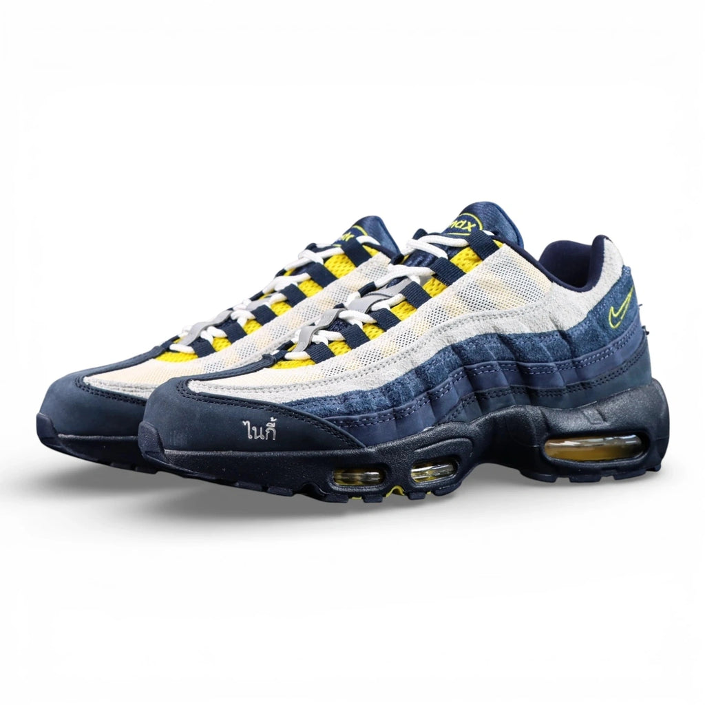 Eric Koston x Nike SB x Air Max 95 Obsidian Speed Yellow 2025 - Lateral Side View with Pikachu on Sofa Showing Full Navy Suede Upper White Terry Cloth Toe Box and Volt Swoosh