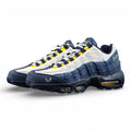 Eric Koston x Nike SB x Air Max 95 Obsidian Speed Yellow 2025 - Lateral Side View with Pikachu on Sofa Showing Full Navy Suede Upper White Terry Cloth Toe Box and Volt Swoosh