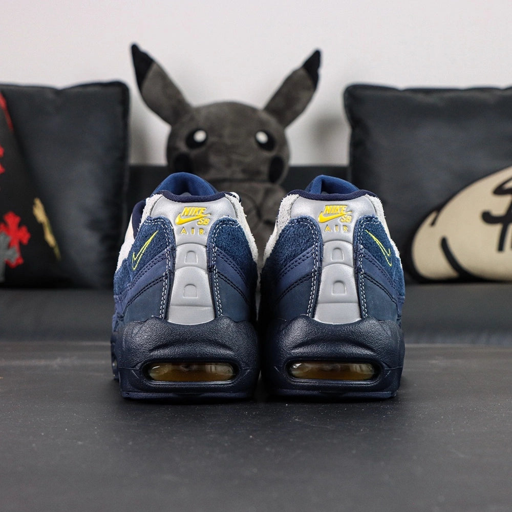 Eric Koston x Nike SB x Air Max 95 Obsidian Speed Yellow 2025 - Pair Top Down View on Dark Background Showing Koston and Airmax Oval Tongue Badges and Mixed White and Yellow Lacing