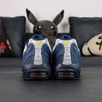Eric Koston x Nike SB x Air Max 95 Obsidian Speed Yellow 2025 - Pair Top Down View on Dark Background Showing Koston and Airmax Oval Tongue Badges and Mixed White and Yellow Lacing