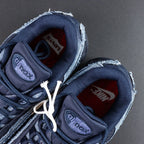 Levis x Air Max 95 OG Obsidian 2025 - Quarter Panel Close Up Showing Tonal Navy Swoosh Stitched into Washed Indigo Denim and Raw Edge Seam Fraying on Dark Background