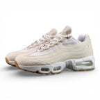 Levis x Air Max 95 OG Light Orewood Brown 2025 - Pair Three Quarter Lateral View on Dark Background Showing Full Cream Ecru Denim Upper Raw Edge Fraying and Tonal White Swoosh