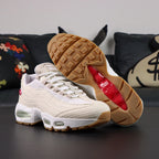 Levis x Air Max 95 OG Light Orewood Brown 2025 - Pair Rear View with Pikachu on Sofa Showing Tonal Nike Air Heel Counter Levis Red Tab and Mint Green Air Units