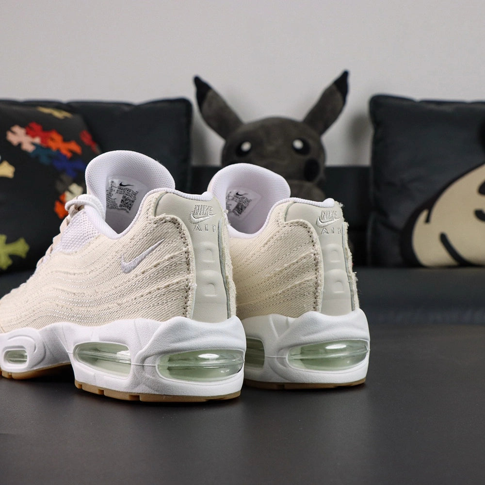 Levis x Air Max 95 OG Light Orewood Brown 2025 - Pair Rear View with Pikachu on Sofa Showing Tonal Nike Air Heel Counter Levis Red Tab on Right Shoe and Mint Air Units