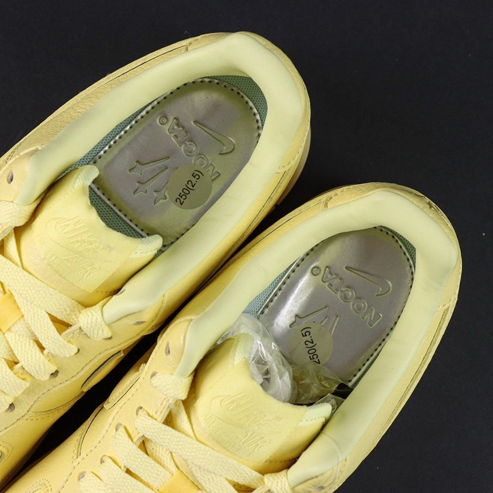 NOCTA x Air Force 1 Low Certified Lover Boy Citron Tint - pair overhead flat lay black background