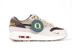 Air Max 1 87 Premium PE University of Oregon - Heel Three Quarter View on White Background Showing Yellow Once A Duck Embroidered Motto on Dark Brown Leopard Panel Iridescent Bronze Copper Heel Counter and Oregon O Hang Tag