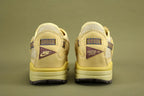 Air Max 1 Cactus Jack Saturn Gold Tea Tree Mist - Full Lateral Single Shoe View on Olive Background Showing Complete Lateral Profile Saturn Gold Woven Swoosh Cream Woven Mesh Multicolour Webbing Lace Loops Teal Lace Lock White Hang Tag Saturn Gold Suede Mudguard and Saturn Gold AM1 Midsole with Dark Grey Outsole