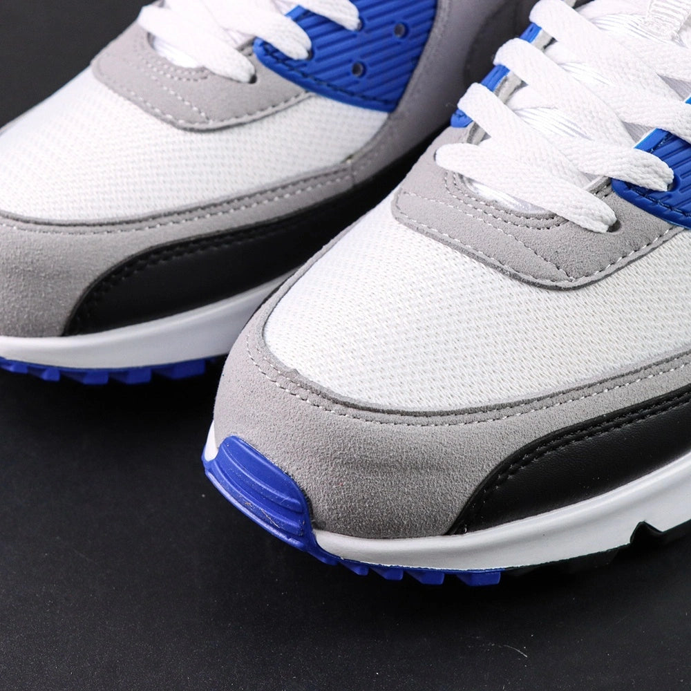 Air Max 90 Hyper Royal 2020 - Pair Three Quarter Lateral View on Dark Background Showing White Leather Toe Box Grey Suede Quarter Panel Black Mudguard Hyper Royal Blue Corduroy Rear Panel and Grey Tonal Swoosh