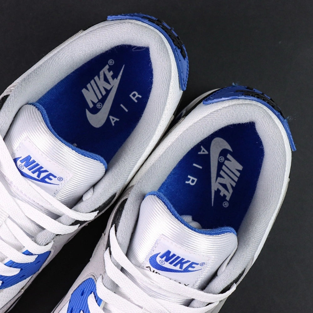 Air Max 90 Hyper Royal 2020 - Pair Three Quarter Heel View with Pikachu on Sofa Showing Hyper Royal Blue Rear Panel Heel Badge Air Max Midsole Text and Split Blue Black Outsole
