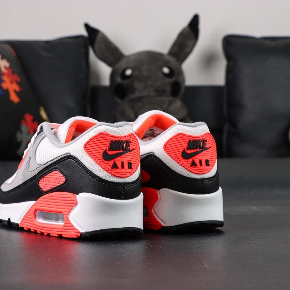 Air Max 90 Infrared 2020 - Pair Three Quarter Lateral View with Pikachu on Sofa Showing Full Upper Construction Infrared Red Corduroy Panel Red Air Max Midsole Text and Split Red Black Outsole