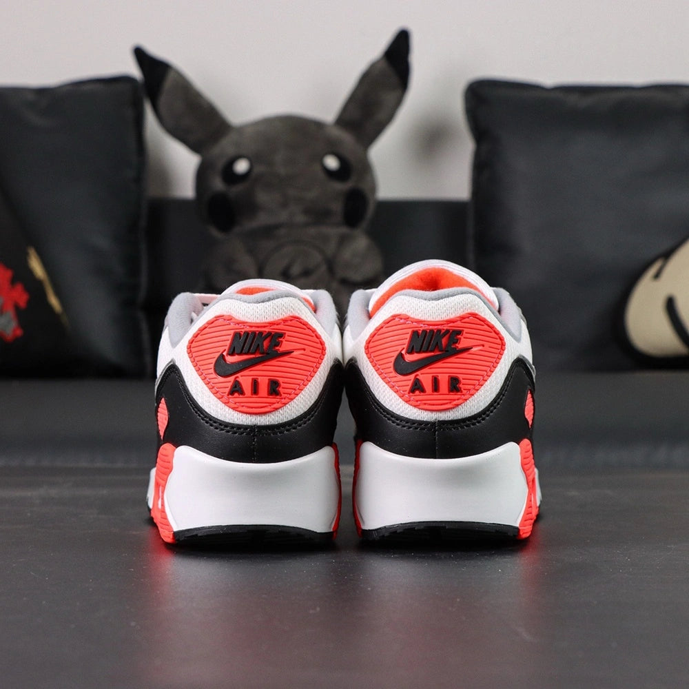 Air Max 90 Infrared 2020 - Outsole and Lateral Side View on Dark Background Showing Black Square Lug Waffle Tread Forefoot Outsole and Infrared Red Rubber Heel Outsole with Translucent Clear Air Unit