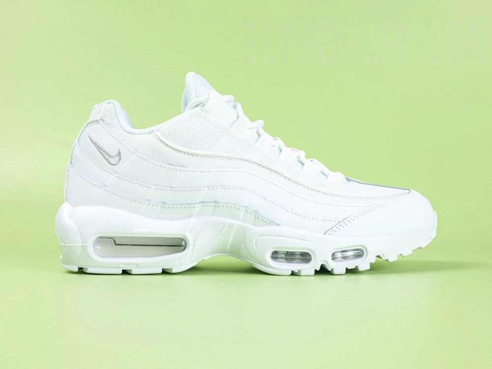 Air Max 95 Essential White Grey Fog - Tongue Close Up on Green Background Showing Silver Grey Embroidered Oval Airmax Badge on Pale Ice Blue White Mesh Tongue