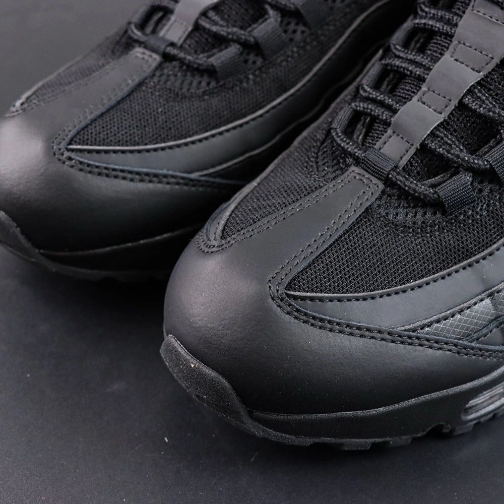 Air Max 95 OG Black Anthracite 2025 - Pair Top Down Angled View on Dark Background Showing Full Tonal Black Upper Black to Anthracite Gradient Spine Overlays and Silver Airmax Tongue Badge