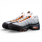 Air Max 95 OG Bright Mandarin 2.0 2025 - Pair Heel Rear View with Pikachu on Sofa Showing Grey Suede Heel Badge with Black Nike Air Text and Bright Mandarin Orange Swoosh and Orange Translucent Heel Air Units