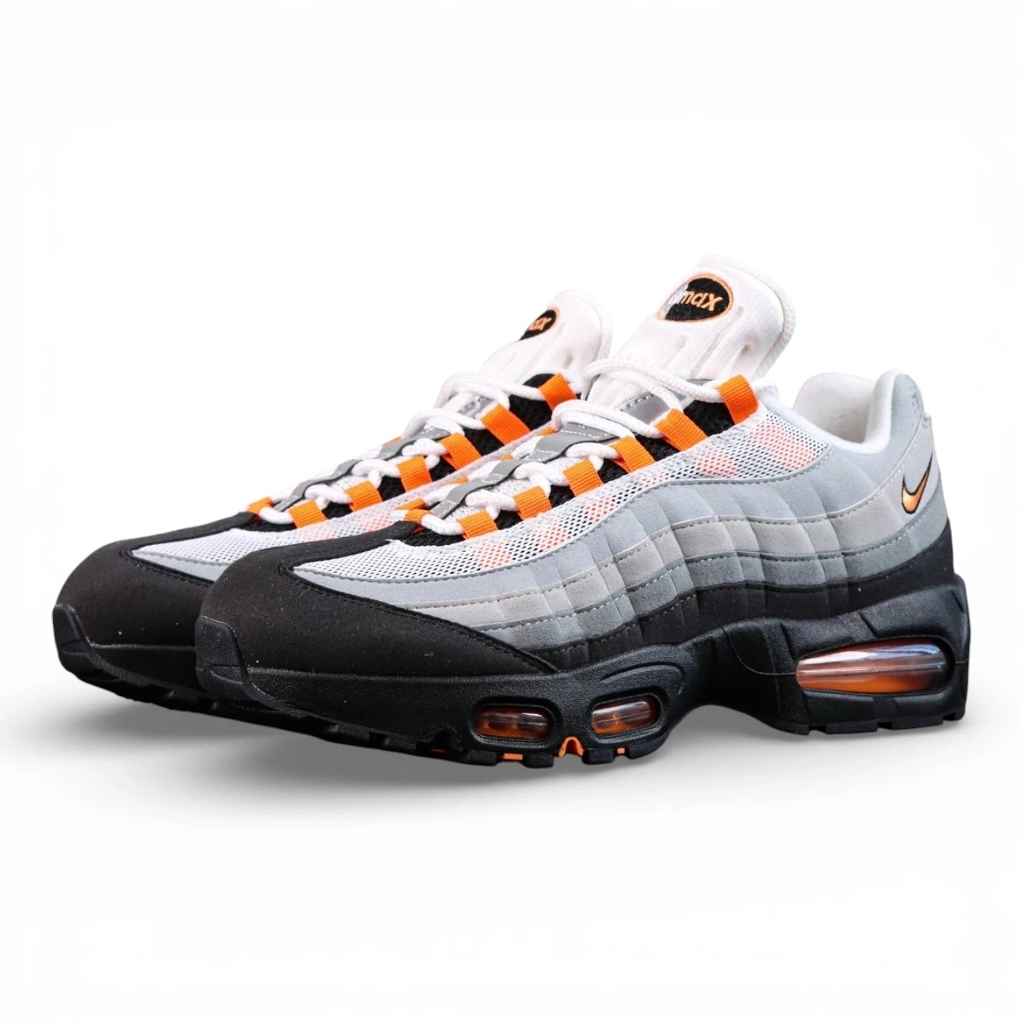 Air Max 95 OG Bright Mandarin 2.0 2025 - Pair Heel Rear View with Pikachu on Sofa Showing Grey Suede Heel Badge with Black Nike Air Text and Bright Mandarin Orange Swoosh and Orange Translucent Heel Air Units
