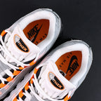 Air Max 95 OG Bright Mandarin 2.0 2025 - Pair Heel Three Quarter Rear View with Pikachu on Sofa Showing Grey Suede Heel Badge Orange Swoosh Orange Translucent Air Units and Black Midsole
