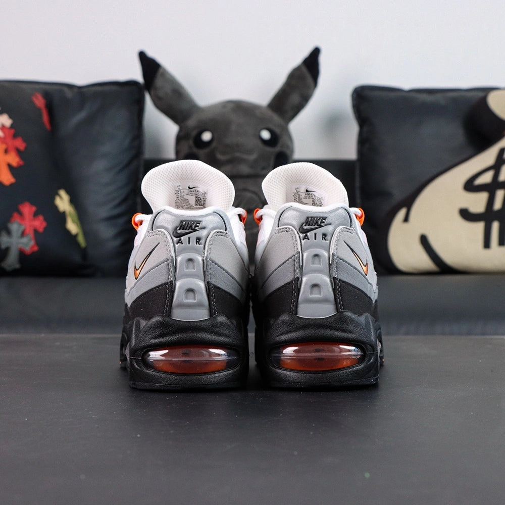 Air Max 95 OG Bright Mandarin 2.0 2025 - Single Lateral Side View with Pikachu on Sofa Showing Full Upper Construction Grey Gradient Spine Orange Mini Swoosh Orange Lace Loops and Orange Translucent Heel Air Unit