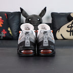Air Max 95 OG Bright Mandarin 2.0 2025 - Single Lateral Side View with Pikachu on Sofa Showing Full Upper Construction Grey Gradient Spine Orange Mini Swoosh Orange Lace Loops and Orange Translucent Heel Air Unit