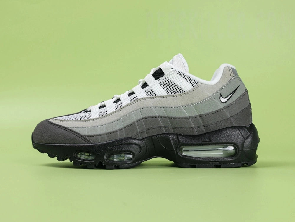 Air Max 95 OG Grey Gradient - Outsole View on Green Background Showing Full Black AM95 Square Block Waffle Tread with Central Translucent Window Revealing 25 PSI Insole Graphic