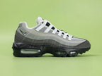 Air Max 95 OG Grey Gradient - Toe Box Forefoot Close Up on Green Background Showing Dark Charcoal Suede Mudguard White Mesh Quarter Panel Light Grey Forefoot Spine and White Flat Laces