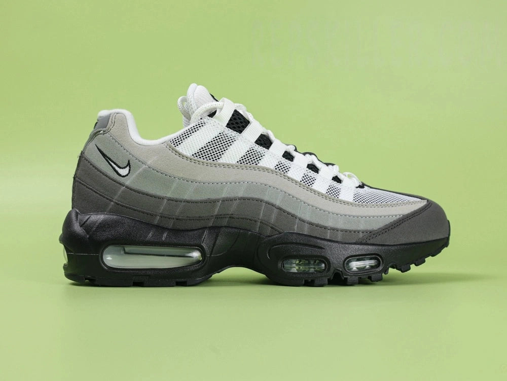 Air Max 95 OG Grey Gradient - Toe Box Forefoot Close Up on Green Background Showing Dark Charcoal Suede Mudguard White Mesh Quarter Panel Light Grey Forefoot Spine and White Flat Laces