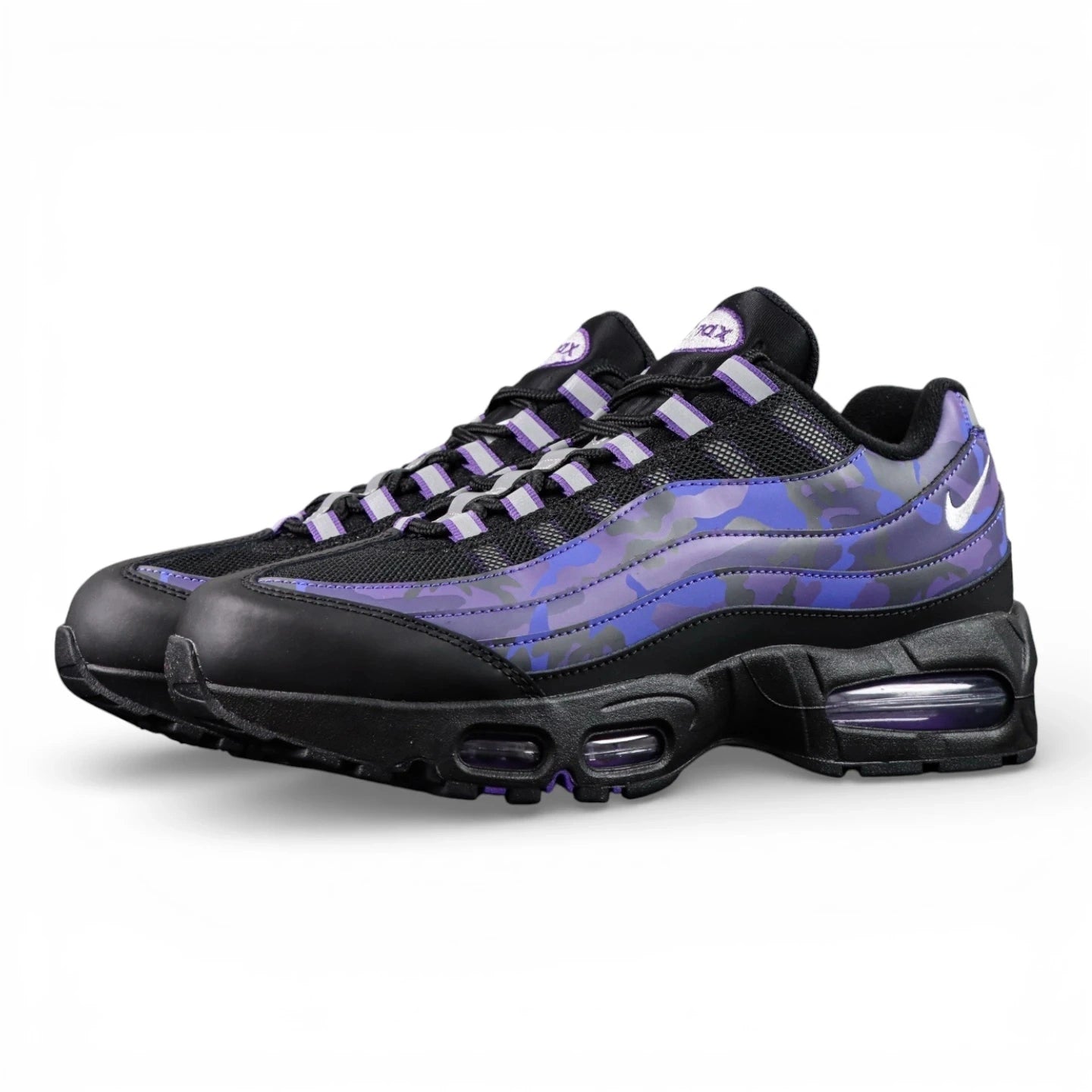 Air Max 95 OG Purple Camo 2025 - Lateral Full Side View with Red Shoebox on Sofa Showing Black Leather Toe Box Black Mesh Base Glossy Purple Camo Spine Overlays White Mini Swoosh and Purple Translucent Air Units