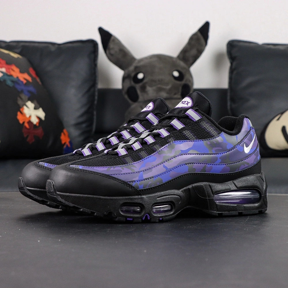 Air Max 95 OG Purple Camo 2025 - Pair Heel Rear View with Pikachu on Sofa Showing Silver Grey Lower Heel Badge with Black Nike Air Text White Swoosh and Purple Camo Upper Heel Panel with Purple Translucent Heel Air Units