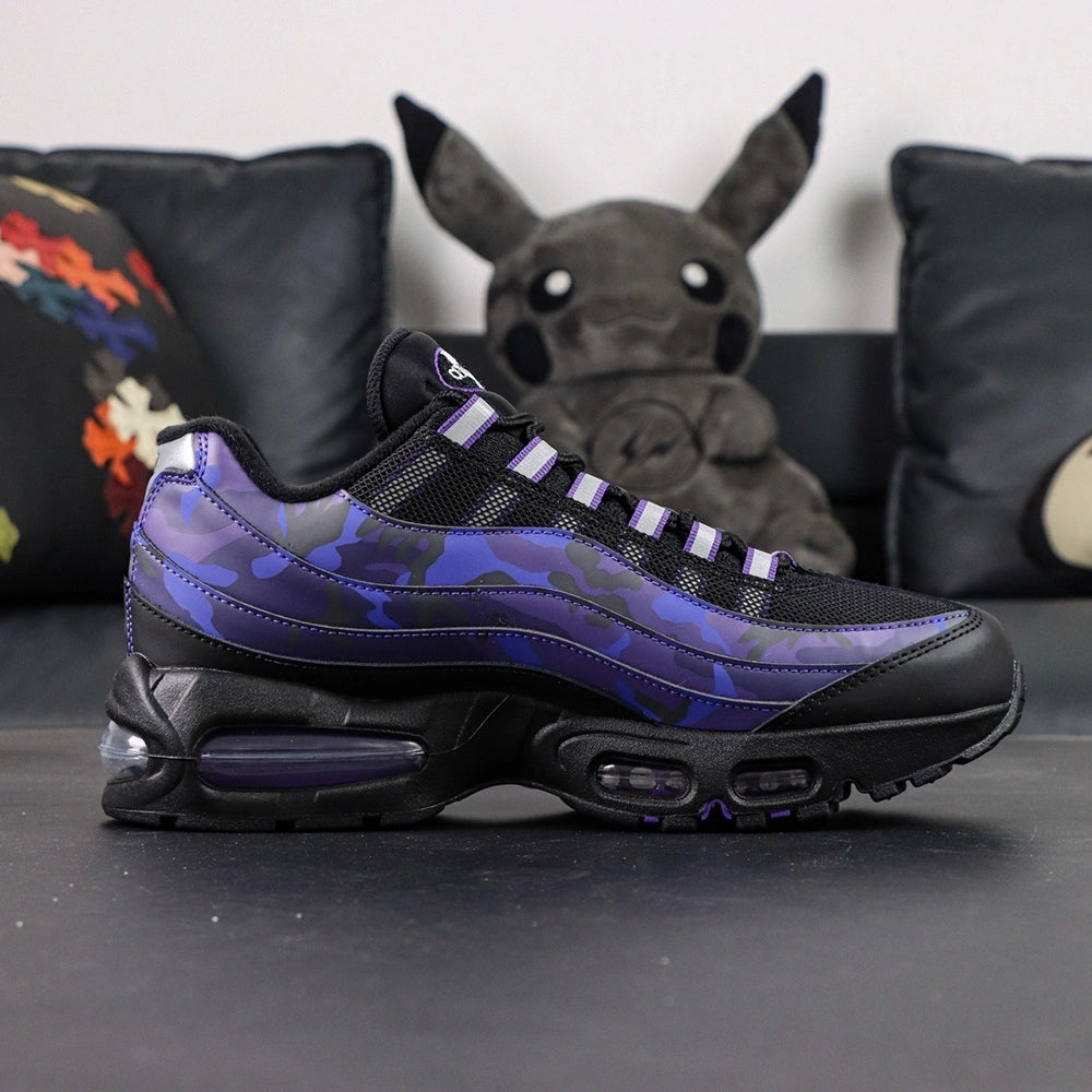 Air Max 95 OG Purple Camo 2025 - Pair Top Down Angled View on Dark Background Showing Full Purple Camo Spine Overlays White Mini Swoosh Black Mesh Base and Purple Airmax Tongue Badge
