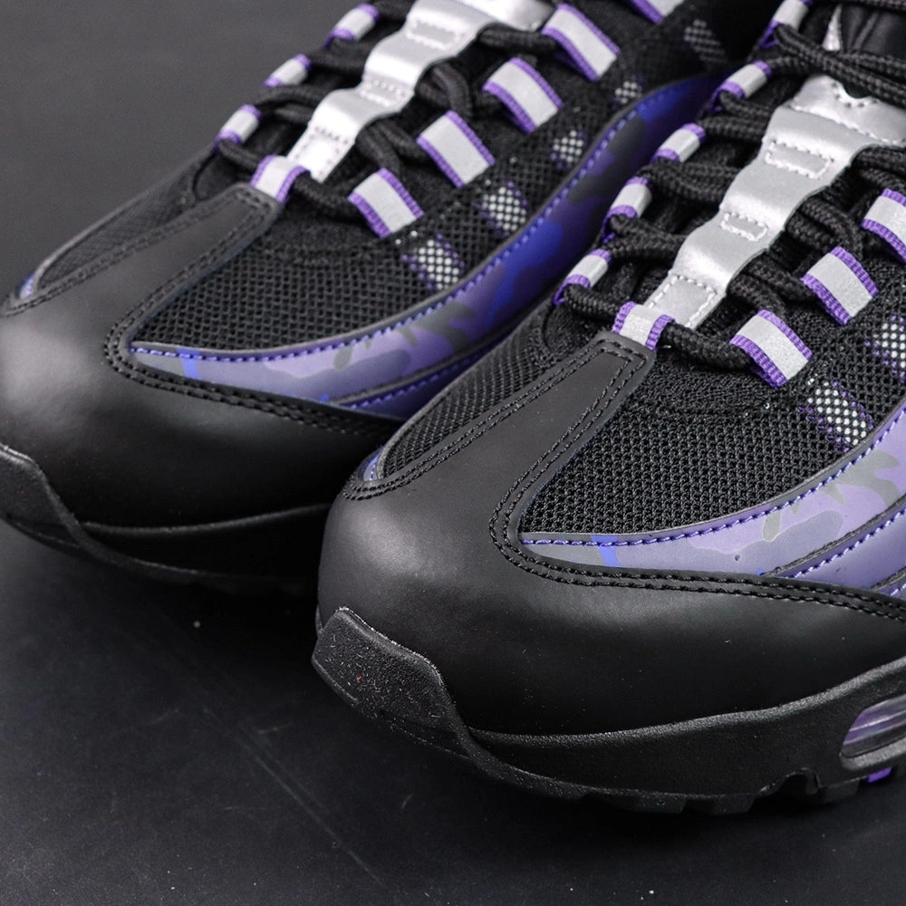 Air Max 95 OG Purple Camo 2025 - Pair Heel Rear View with Pikachu on Sofa Showing Silver Grey Lower Heel Badge Black Nike Air Text White Swoosh Purple Camo Upper Heel Panel and Purple Translucent Heel Air Units
