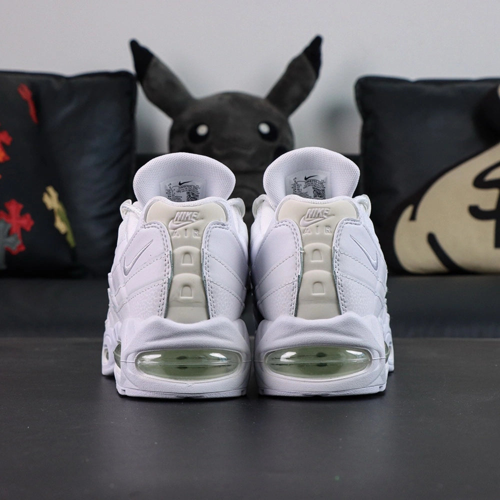 Air Max 95 OG White Pure Platinum 2025 - Pair Lateral and Outsole View with Pikachu on Sofa Showing Full White Rubber AM95 Square Block Waffle Tread Outsole Central Translucent Window and Clear Green Tinted Heel Air Unit