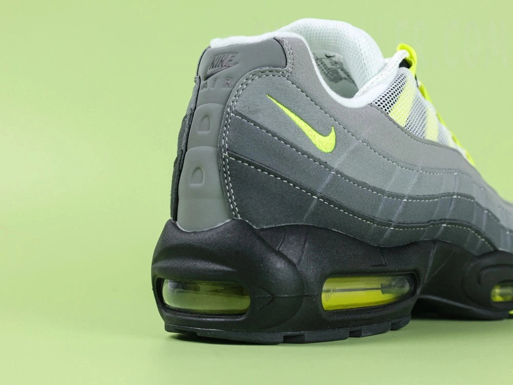 Air Max 95 OG Neon CT1689-001 - Tongue Close Up on Green Background Showing Black White Oval Airmax Badge with Neon Yellow Volt Border on Ice Blue Pale Mint White Mesh Tongue