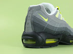 Air Max 95 OG Neon CT1689-001 - Tongue Close Up on Green Background Showing Black White Oval Airmax Badge with Neon Yellow Volt Border on Ice Blue Pale Mint White Mesh Tongue