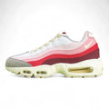 Air Max 95 TT Anatomy of Air - Heel Rear Angled Close Up on Green Background Showing White Heel Badge with Black Nike Air Text Cream Swoosh Pink to Burgundy Gradient Spine Panels with Red Contrast Stitching and Translucent Yellow Tinted Heel Air Unit