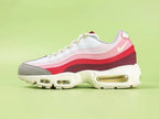 Air Max 95 TT Anatomy of Air - Outsole View on Green Background Showing Full Cream Sand AM95 Square Block Waffle Tread Outsole Central Translucent Window Revealing Pink Camouflage Print Insole with Nike Air Text and Translucent Yellow Tinted Heel Air Unit