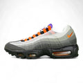 Air Max 95 TT Greedy - Lateral Spine Swoosh Close Up on Green Background Showing Medium Grey Suede Spine Panel with Orange Embroidered Mini Swoosh and Dark Charcoal Lower Spine Panel with Grey Contrast Stitching
