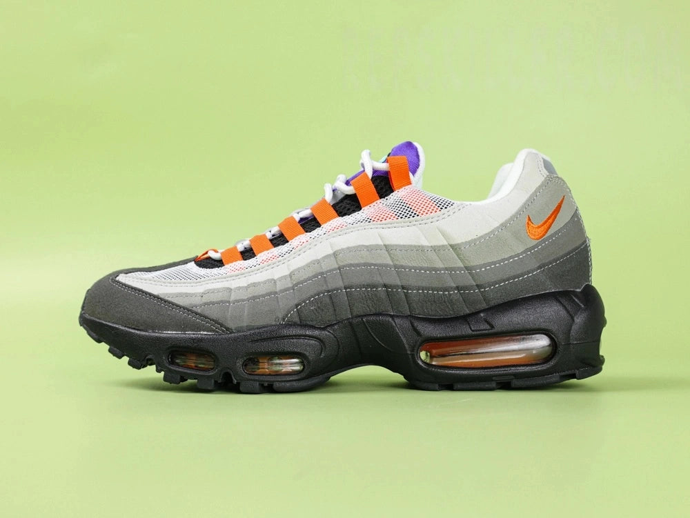 Air Max 95 TT Greedy - Single Lateral Full Side View on Green Background Showing Volt Neon Colourway Dark Charcoal Suede Toe Box White Mesh Base Grey Gradient Spine Volt Mini Swoosh Volt Lace Loops and Volt Translucent Air Units