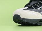 Air Max 95 x Comme des Garçons Charcoal - Heel Angled View on Green Background Showing Silver AM95 Heel Stabiliser AIR Text Black Rope Laces and Black Translucent Heel Air Unit